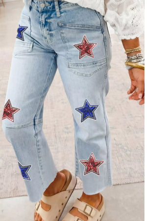 Light wash denim cropped jeans with red and blue sequin star patches and utility pockets.