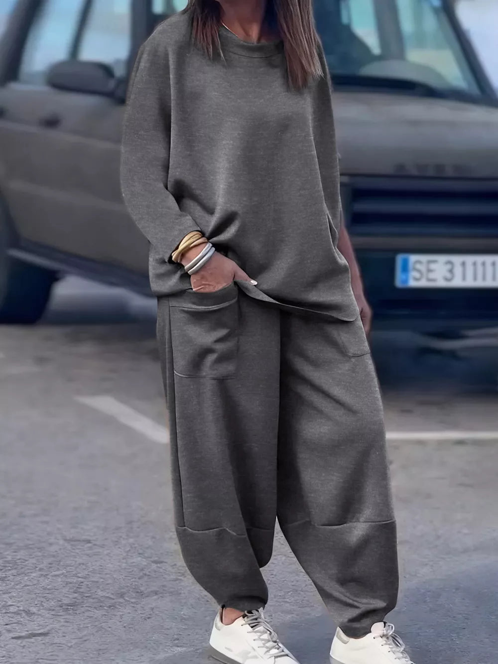 Dark gray crew neck two-piece lounge set with relaxed fit pants and crew neck top.