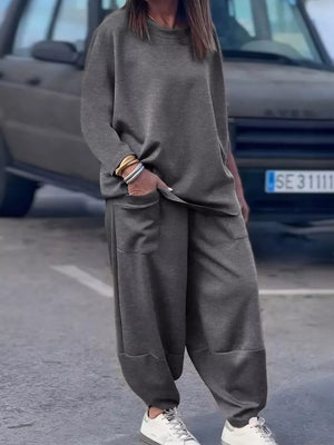 Dark gray crew neck two-piece lounge set with relaxed fit pants and crew neck top.