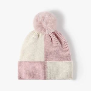 Colorblock knit beanie in blush pink and cream with a fluffy pom pom.