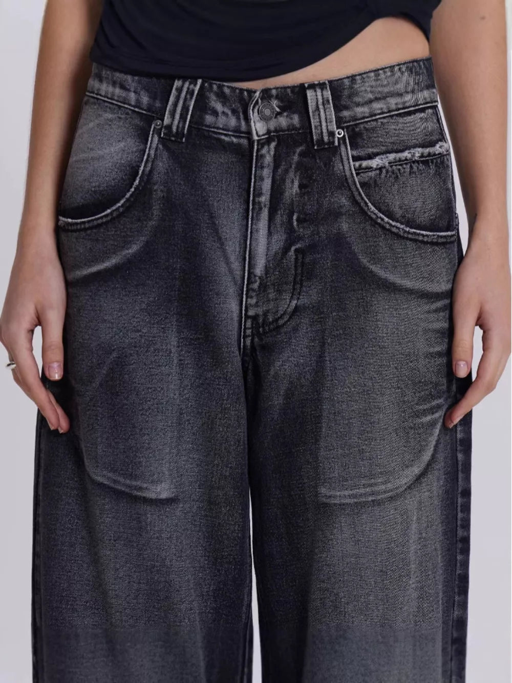 Black vintage wash wide leg jeans with studded details and distressed pockets.