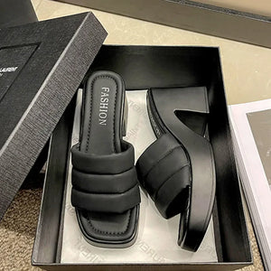 Black padded platform mules with block heel and square toe.