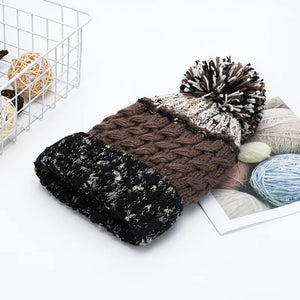 Beanie with cable knit texture, pompom, and speckled cuff.