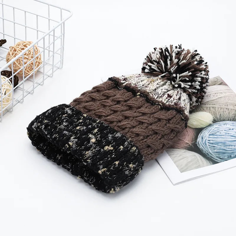 Beanie with cable knit texture, pompom, and speckled cuff.