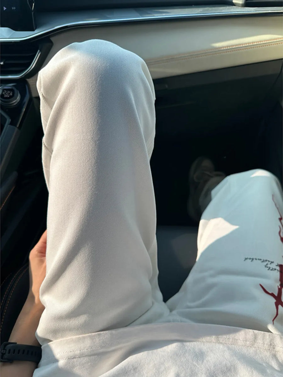 Men's white casual sweatpants with red graphic detail on the leg.