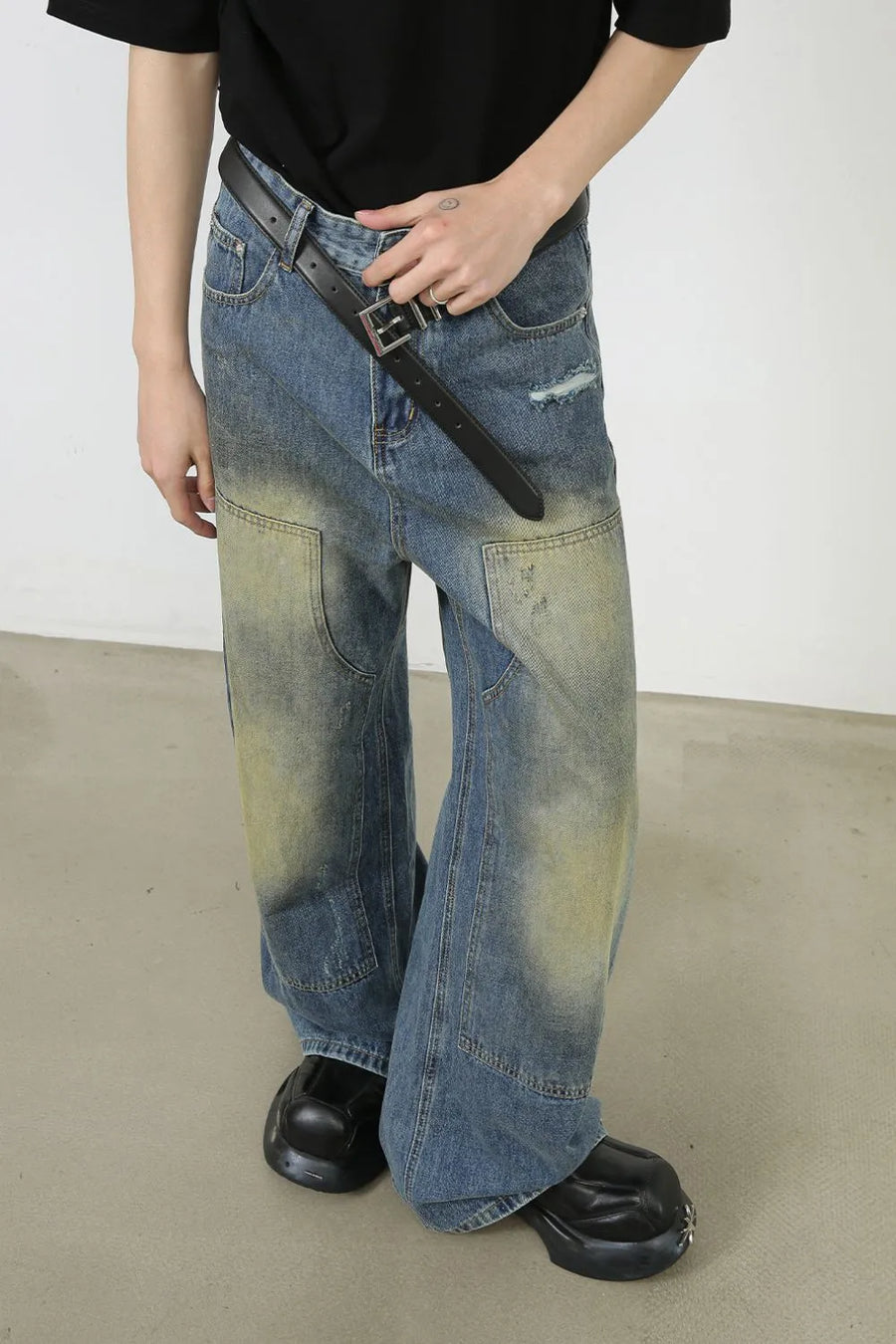 Faded patchwork denim palazzo trousers in medium wash with distressed details and wide legs.