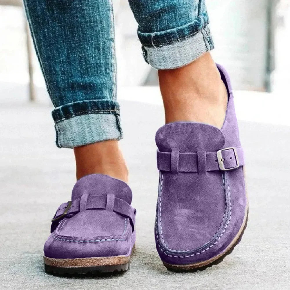 Purple suede buckle mule loafers with contrast stitching and cork sole.