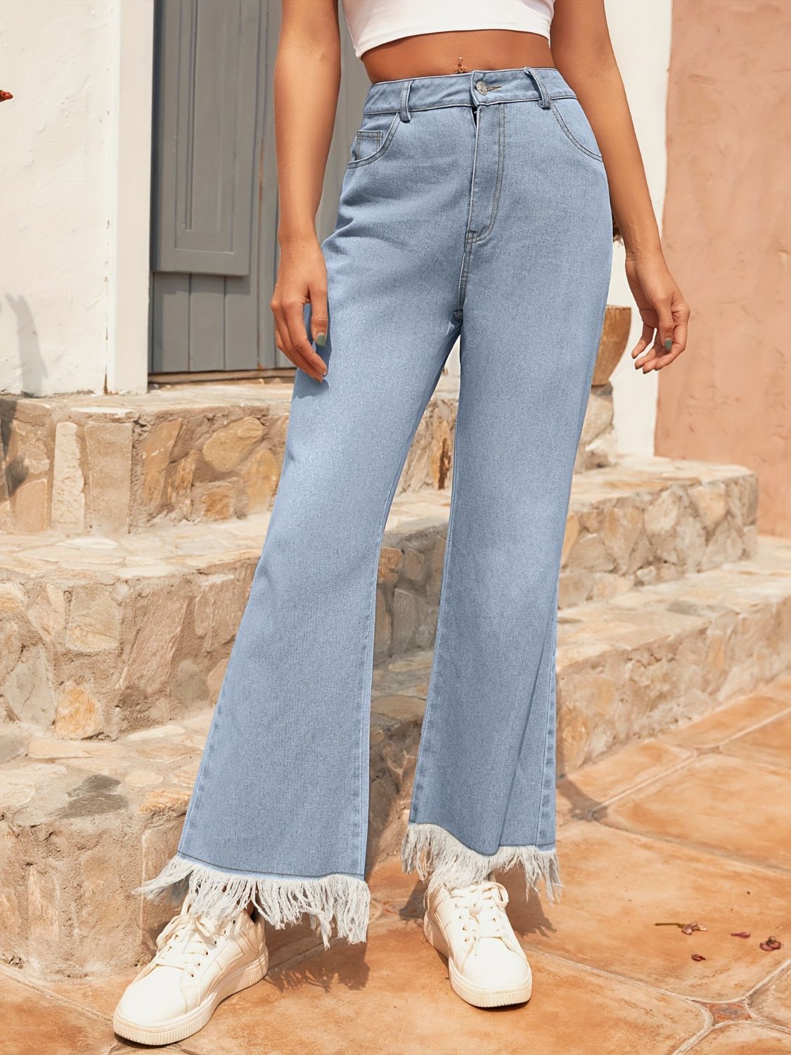 Light wash denim flare jeans with frayed hem detail