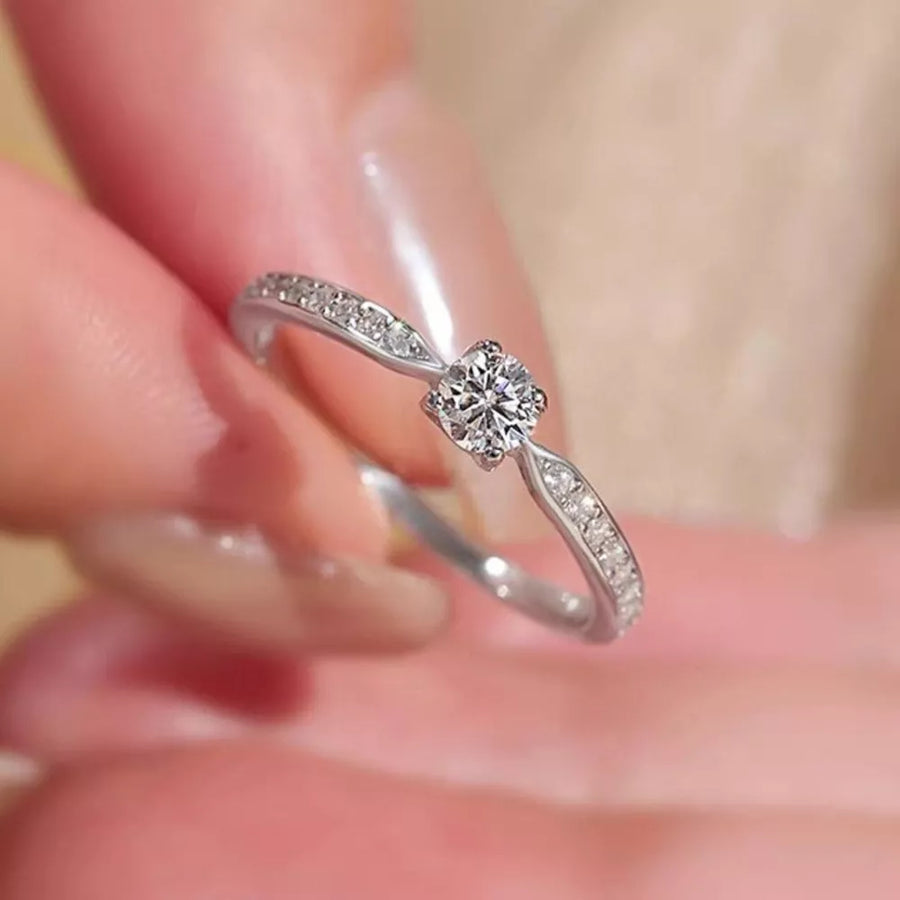 Elegant moissanite ring in sterling silver with a brilliant center stone and pavé band.