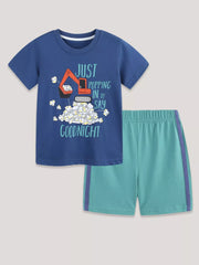 Blue graphic tee with excavator and popcorn, paired with teal shorts with purple trim.