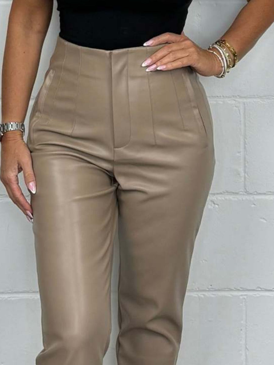 Mocha faux leather tailored trousers with a buttoned fly and pocket details.