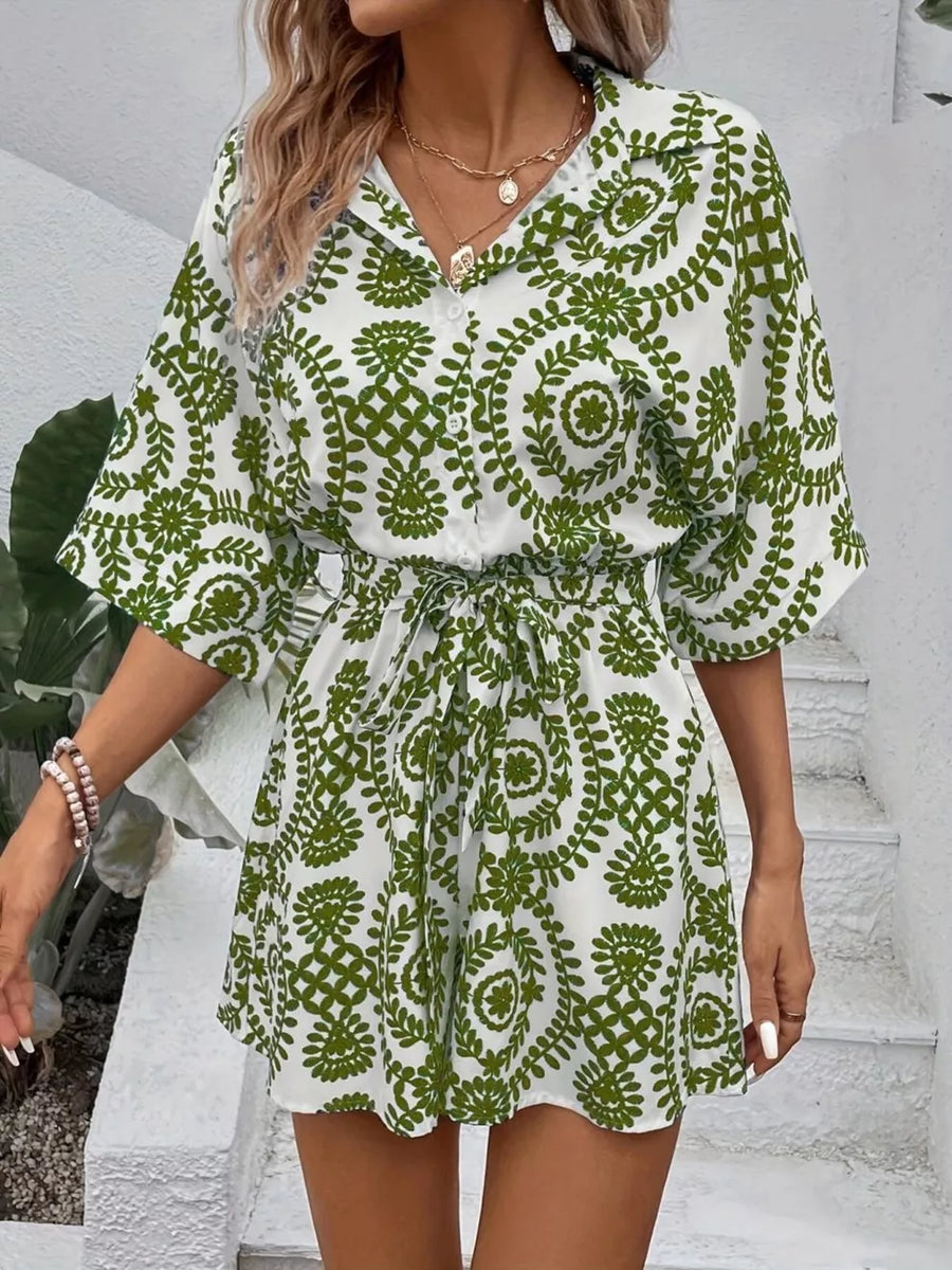 Green printed tie-waist romper with button front and short sleeves.