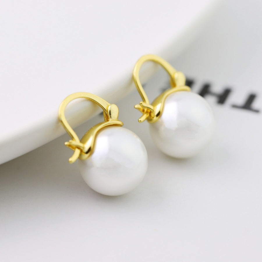 Gold plated pearl hoop earrings with a polished finish and secure latch back closure.
