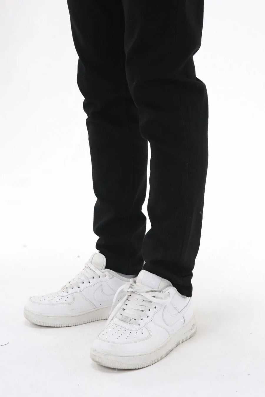 Black slim-fit stretch denim trousers with white sneakers
