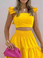 Yellow ruffled crop top and tiered maxi skirt set with smocked waist.