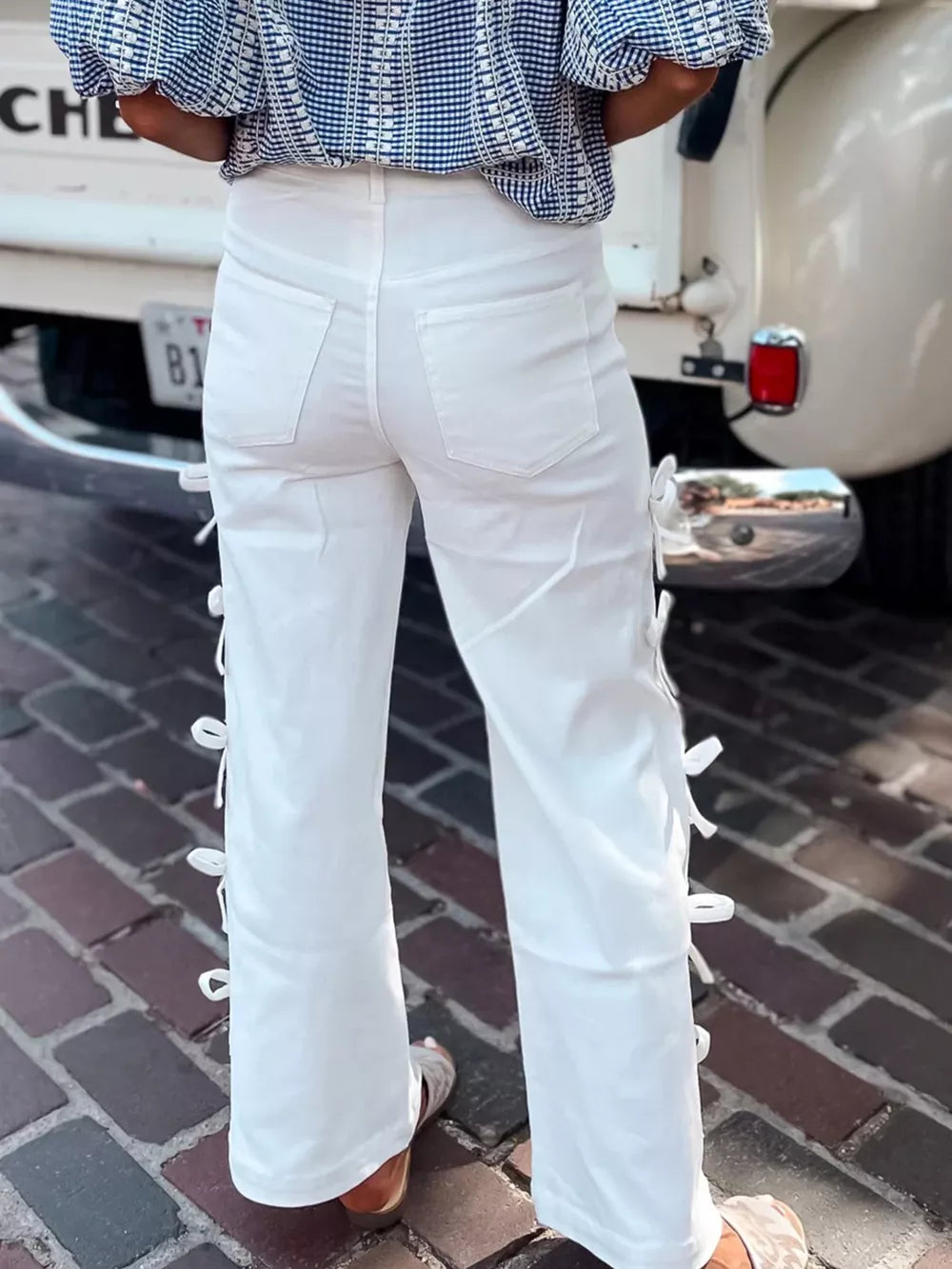 White cotton wide-leg maternity trousers with bow details on the sides.