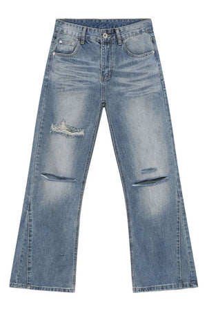 Distressed flare-leg jeans in medium wash denim with ripped details and a split hem.