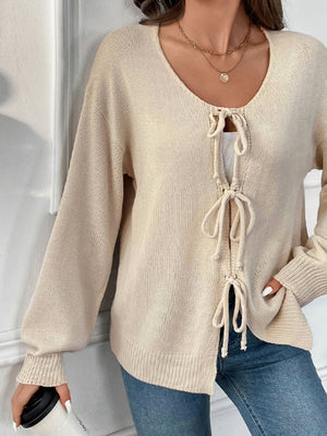 Cream lace-up front knit cardigan with long sleeves and a V-neck.