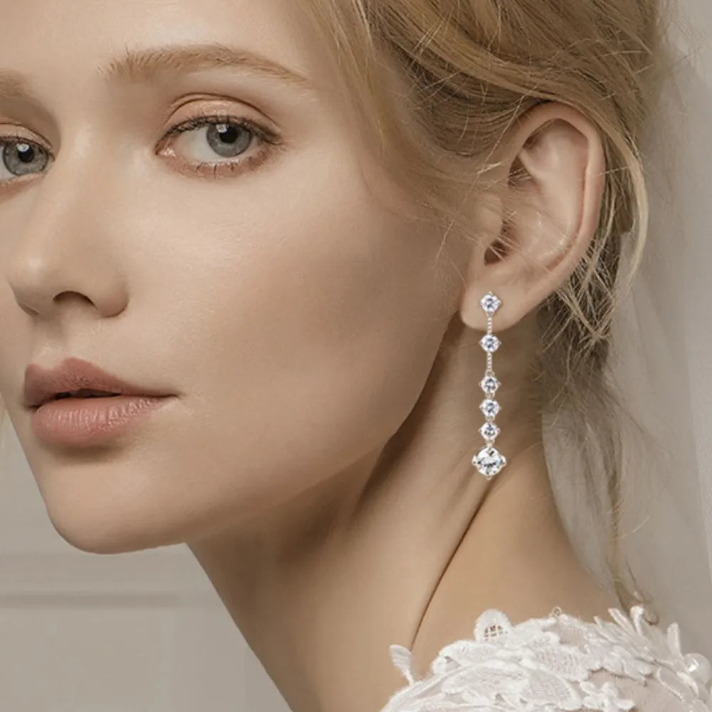 Silver cascading diamond drop earrings with brilliant stones.