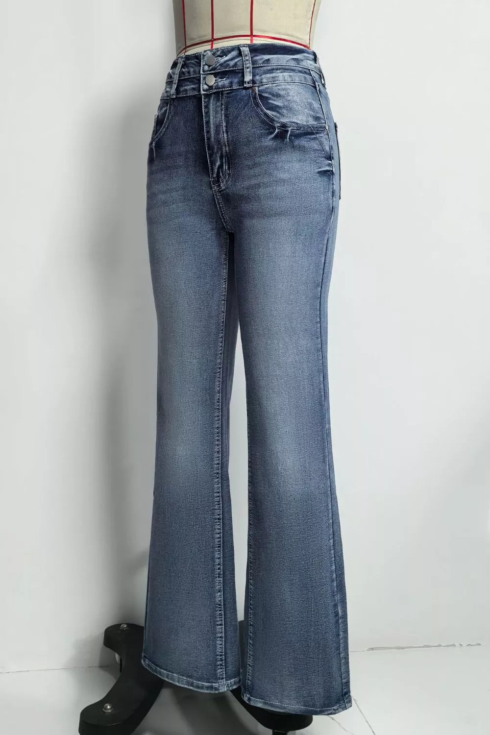 Classic high-waisted flare jeans in blue denim with a buttoned closure and distressed details.