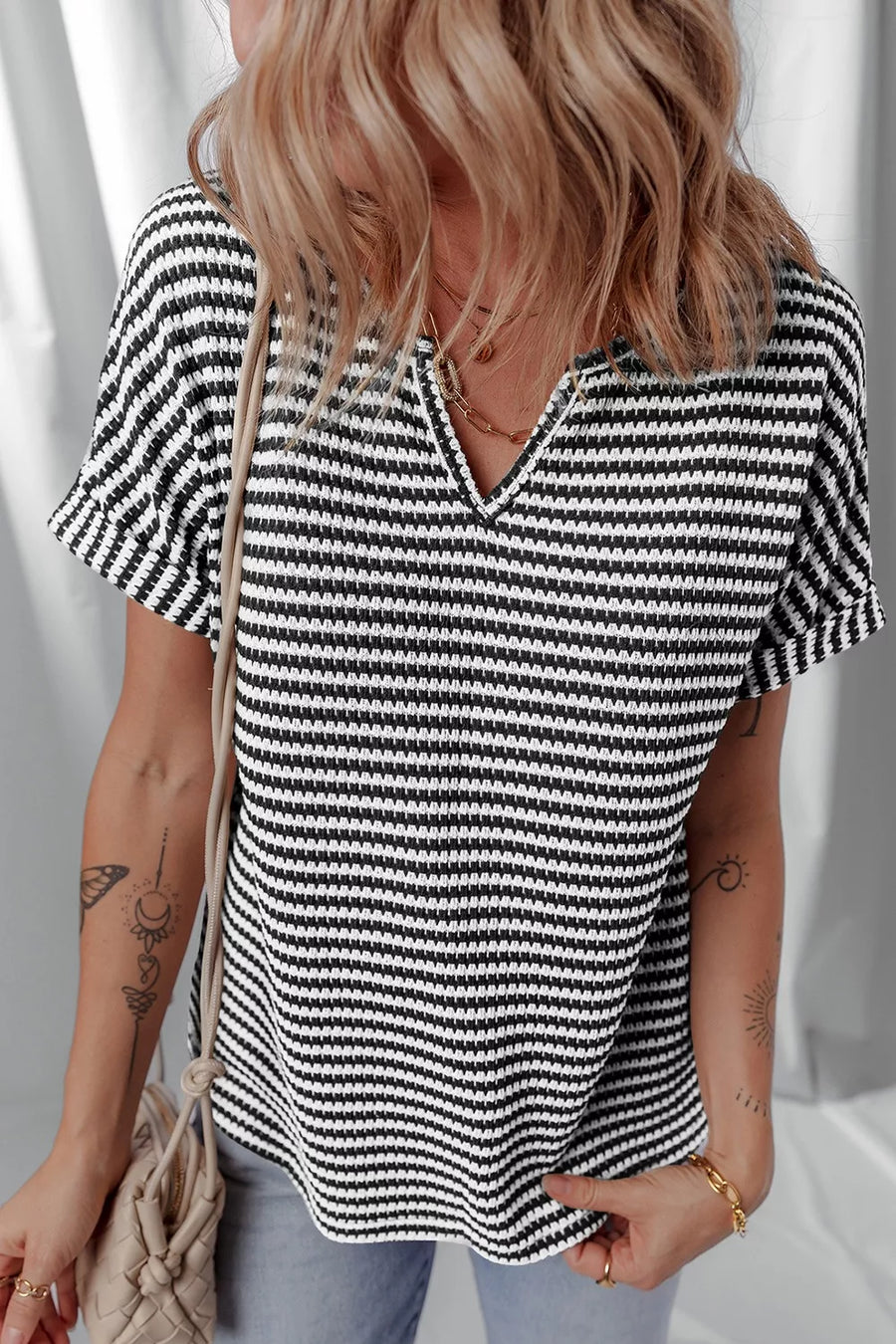 Textured knit t-shirt with black and white stripes and a notched neckline.