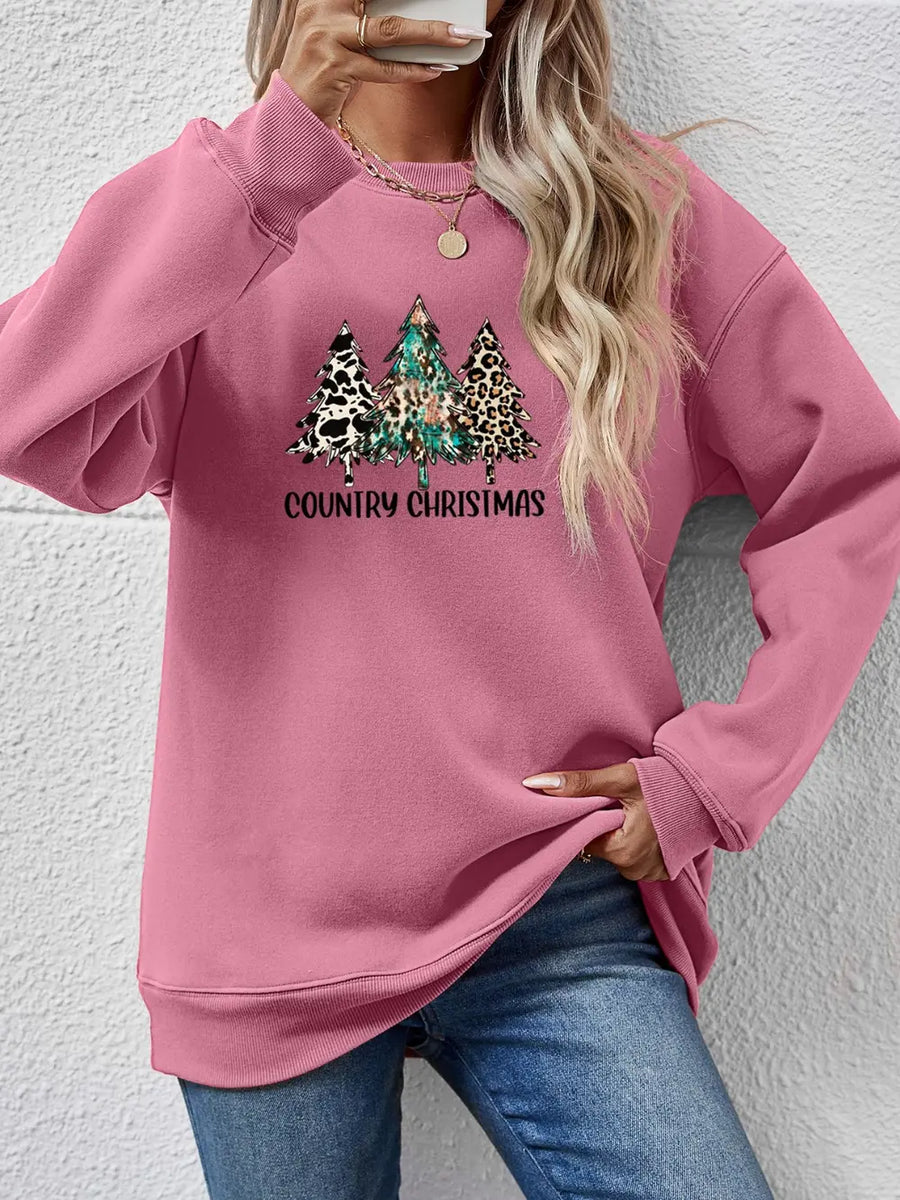 Blush pink graphic sweatshirt with country Christmas trees and text.