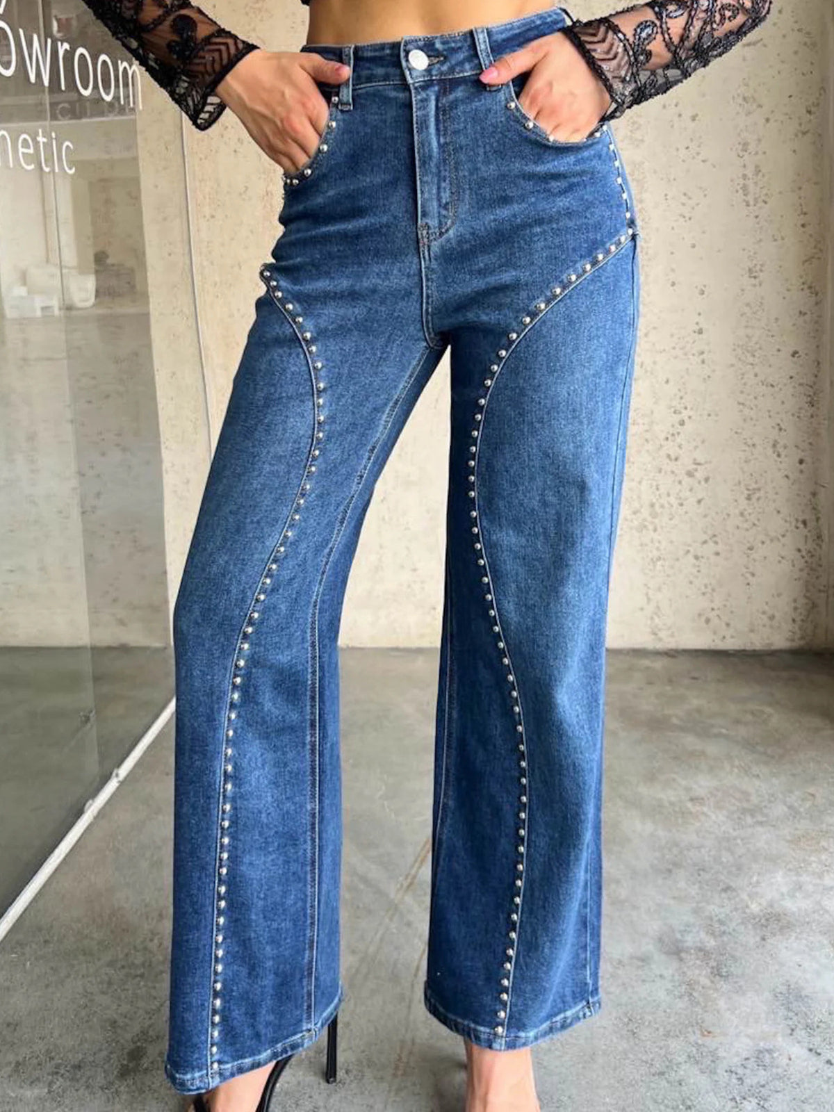 Studded high-waisted wide-leg jeans in dusty blue with button fly and silver stud detailing.