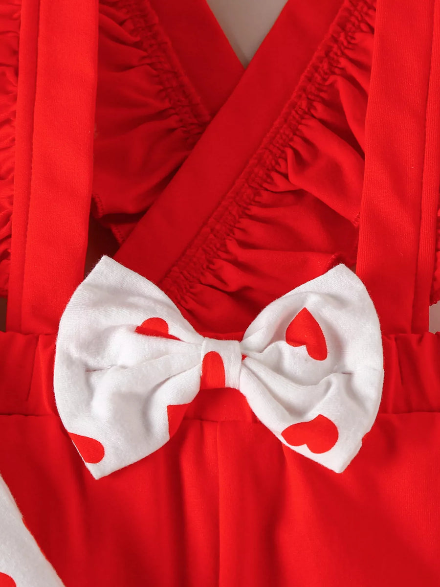 Red baby outfit with heart print bow detail and ruffled neckline.
