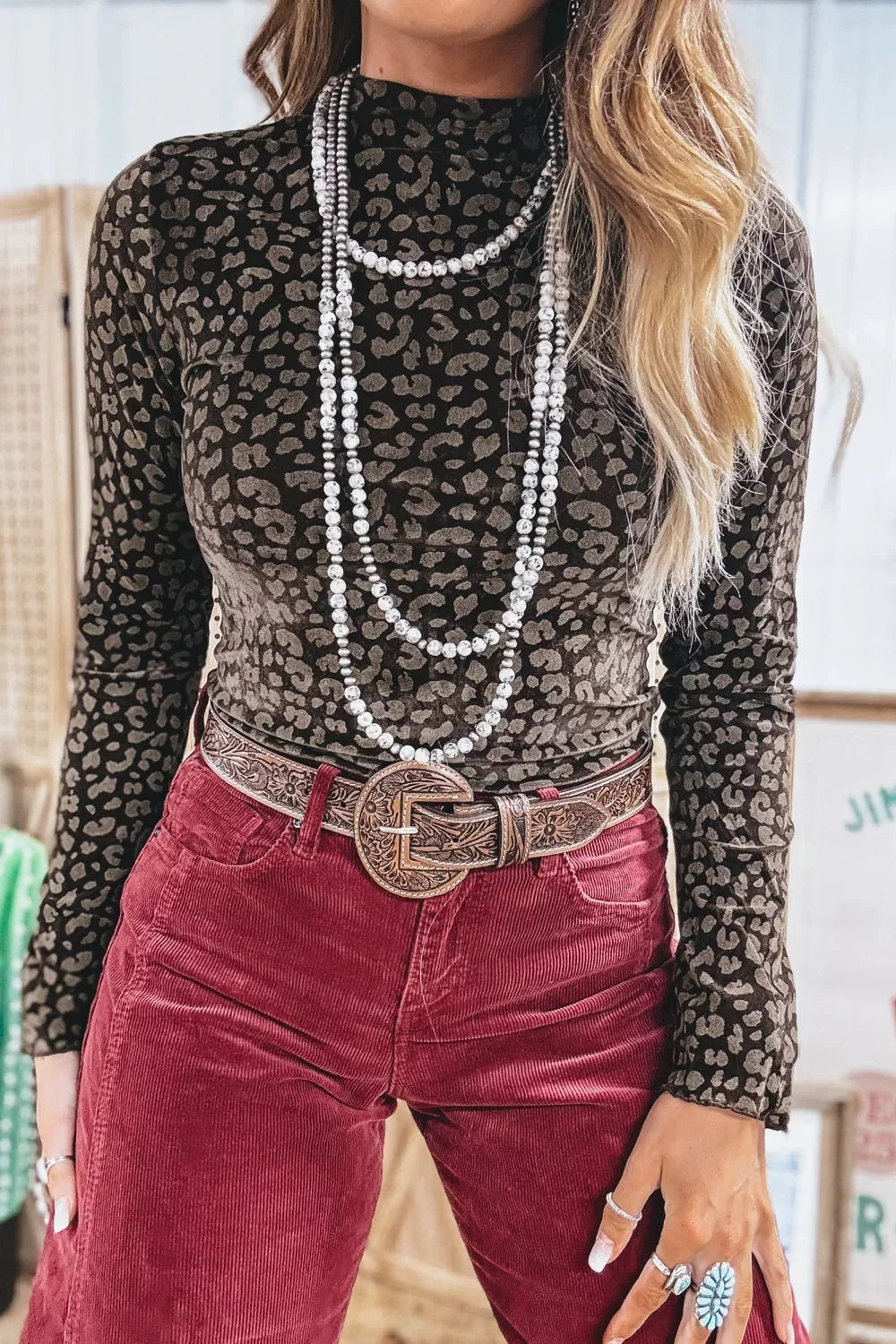 Textured leopard print fitted pullover shirt with mock neck and long sleeves.