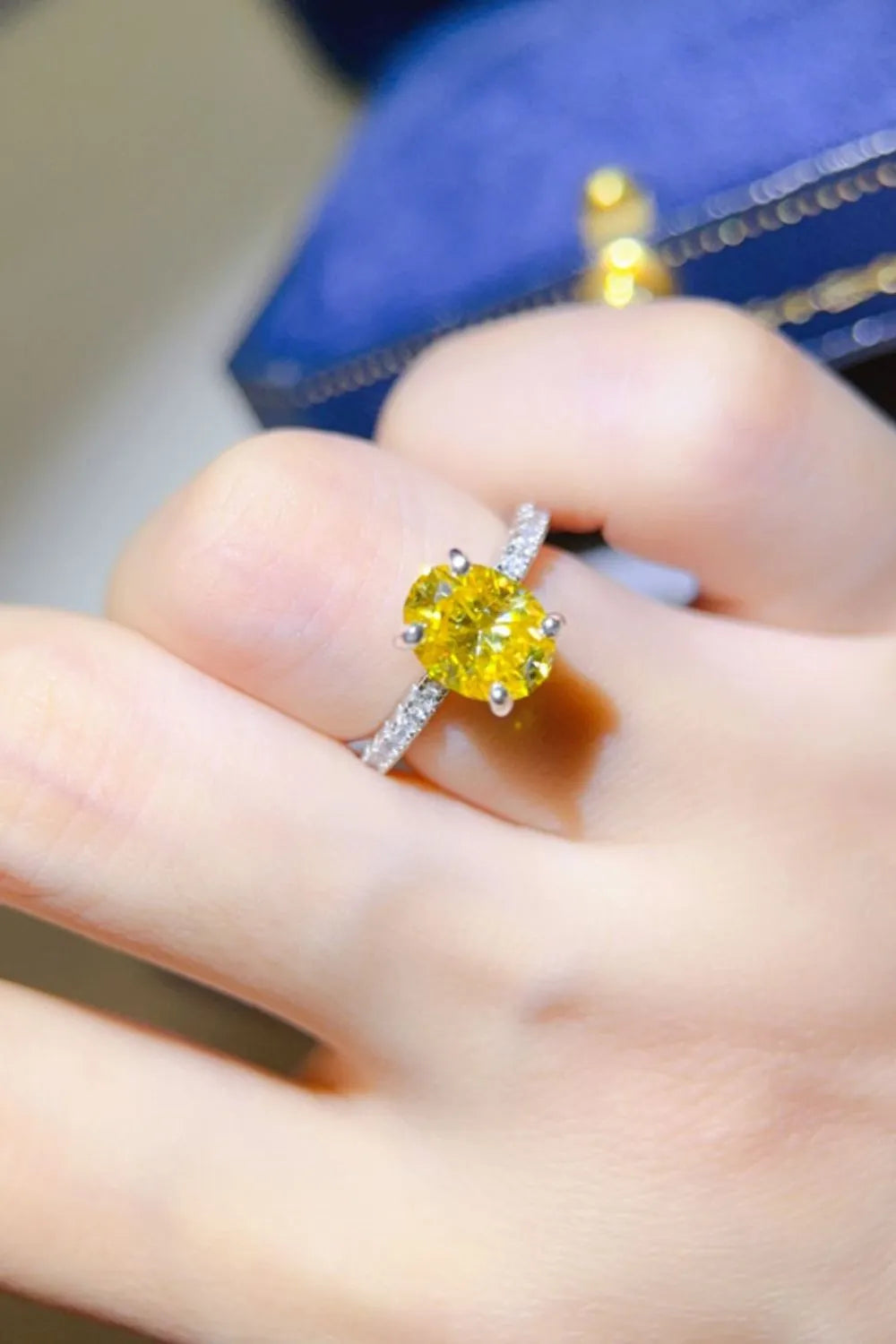 Radiant yellow oval moissanite ring with diamond band on hand