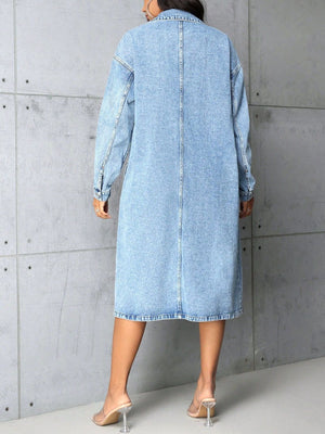 Medium wash denim duster coat with collared neckline, buttoned front, and long sleeves.