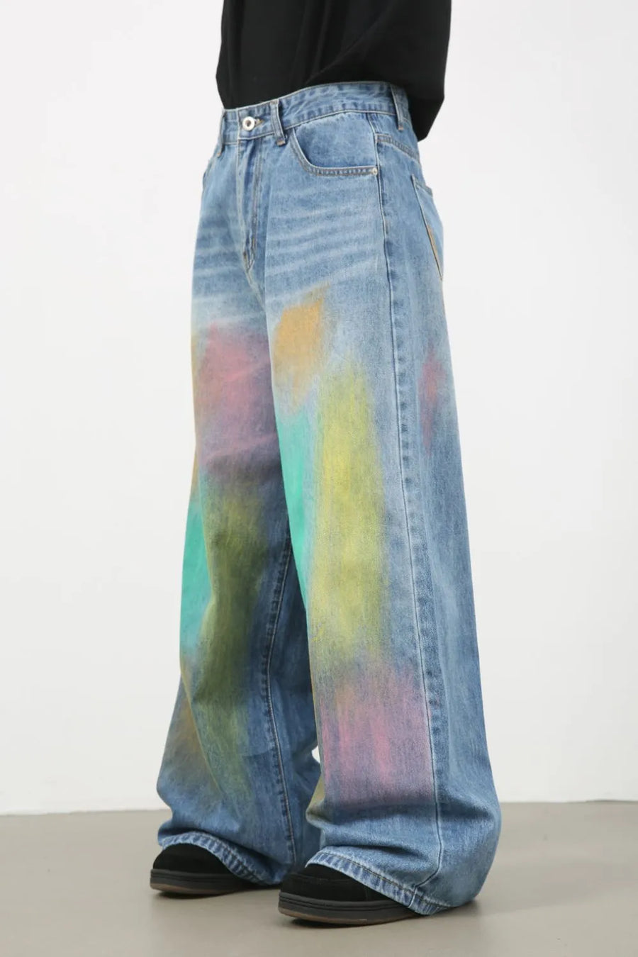 Graffiti wash wide leg denim trousers in medium blue with colorful paint splatters.