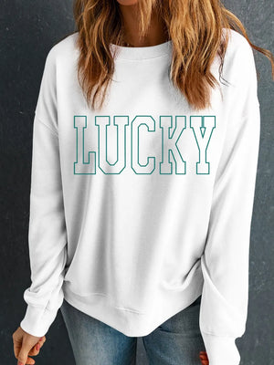 White sweatshirt with green varsity "LUCKY" graphic.