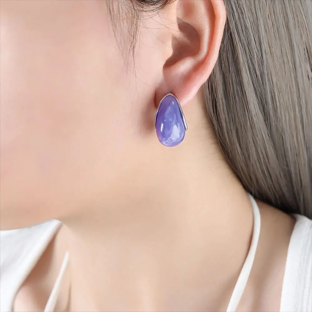 Teardrop resin stud earrings with gold trim in purple.
