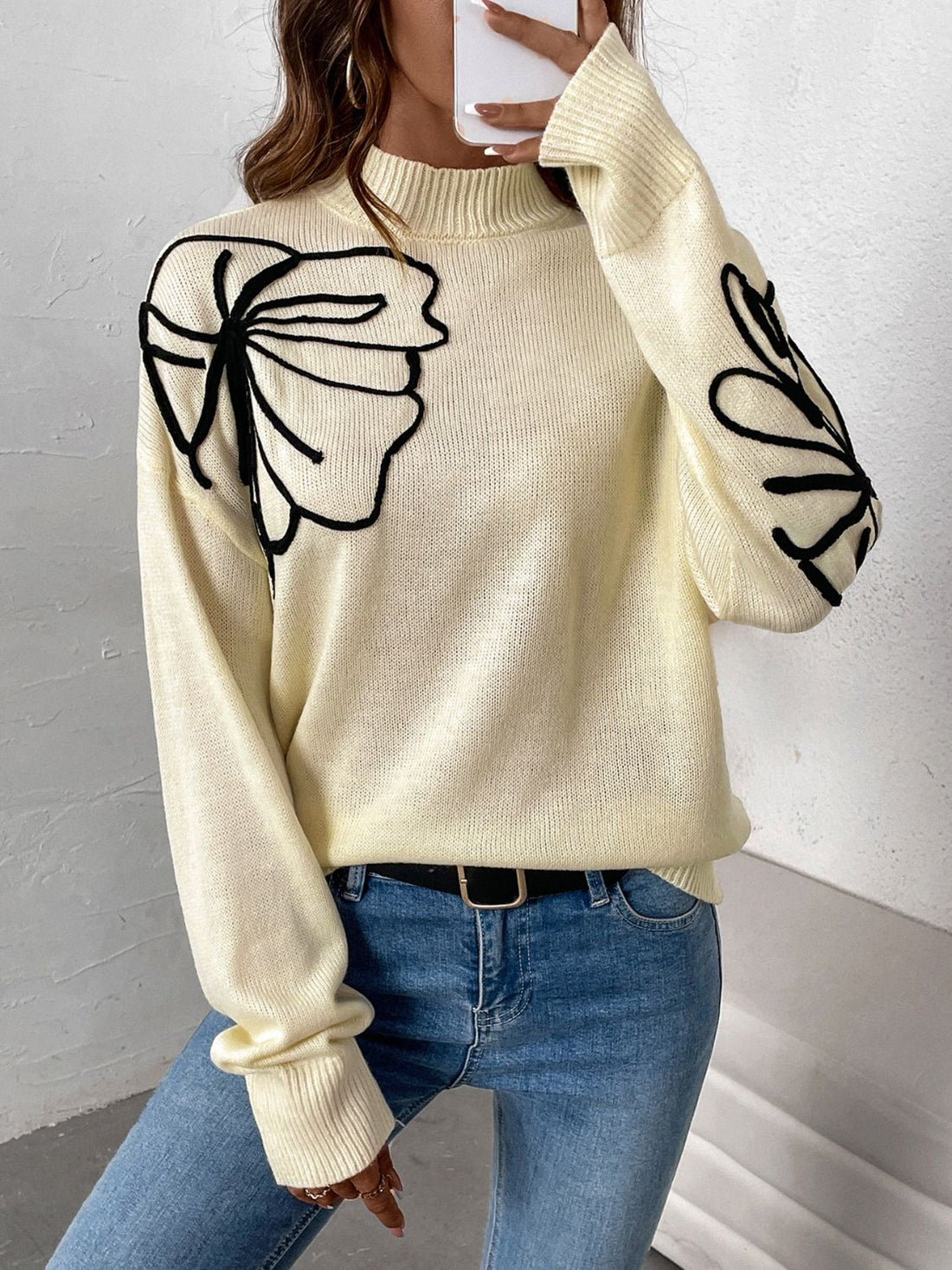 Pastel yellow acrylic knit sweater with black embroidered floral motifs on the shoulder and sleeve.