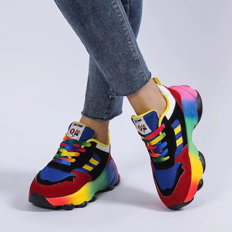Rainbow gradient chunky sneakers with red and mustard accents, featuring colorful laces.