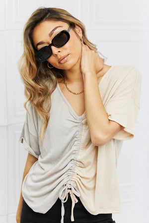 Black oval sunglasses with tortoiseshell sunset lenses and gold chain necklace.