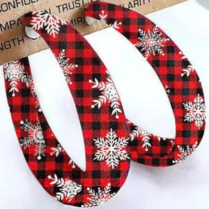 Red buffalo check statement hoop earrings with white snowflakes.