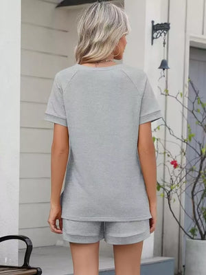 Light gray relaxed two-piece set with drawstring shorts and short sleeve top.