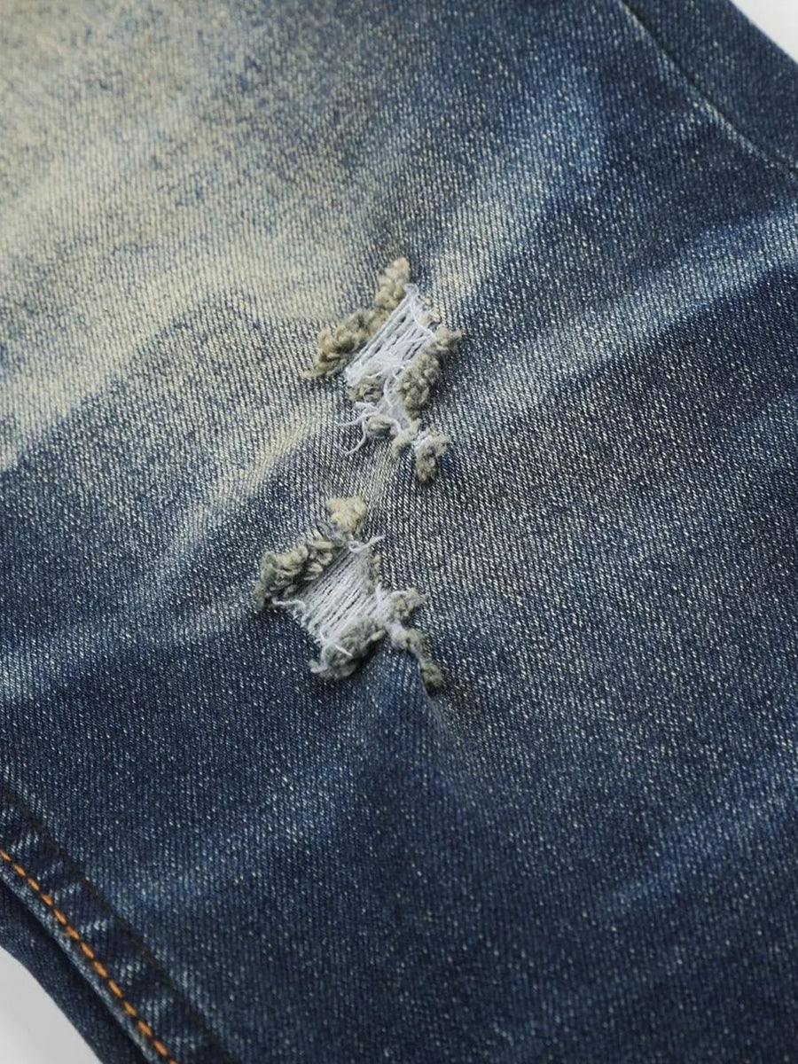 Distressed dark wash flare jeans with ripped details and pocket accents.