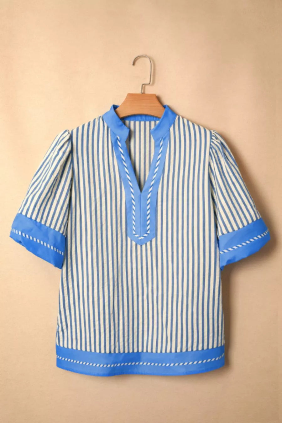 Blue and white striped V-neck shirt with decorative stitching and contrast trim