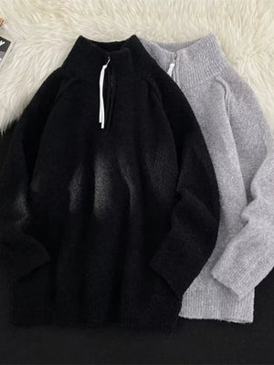 Men's black and gray half-zip sweaters with high necks and textured fabric.
