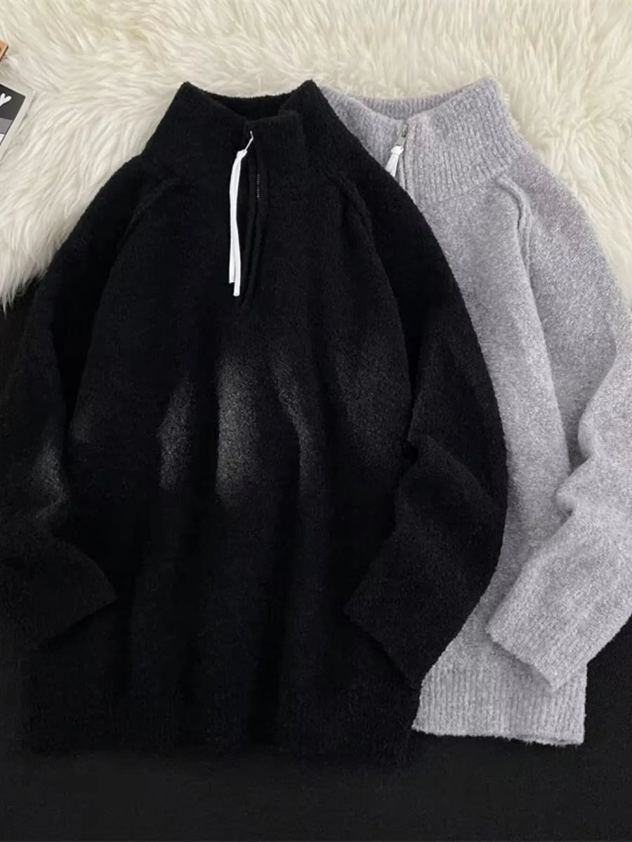 Men's black and gray half-zip sweaters with high necks and textured fabric.