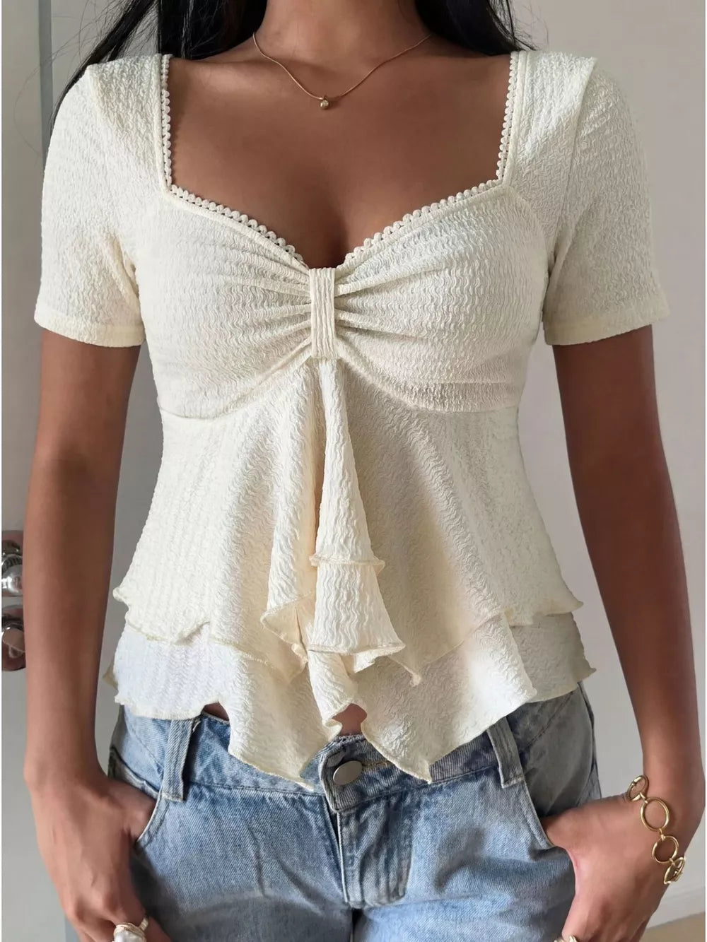 Cream textured square neck short sleeve top with ruched front and tiered ruffle hem