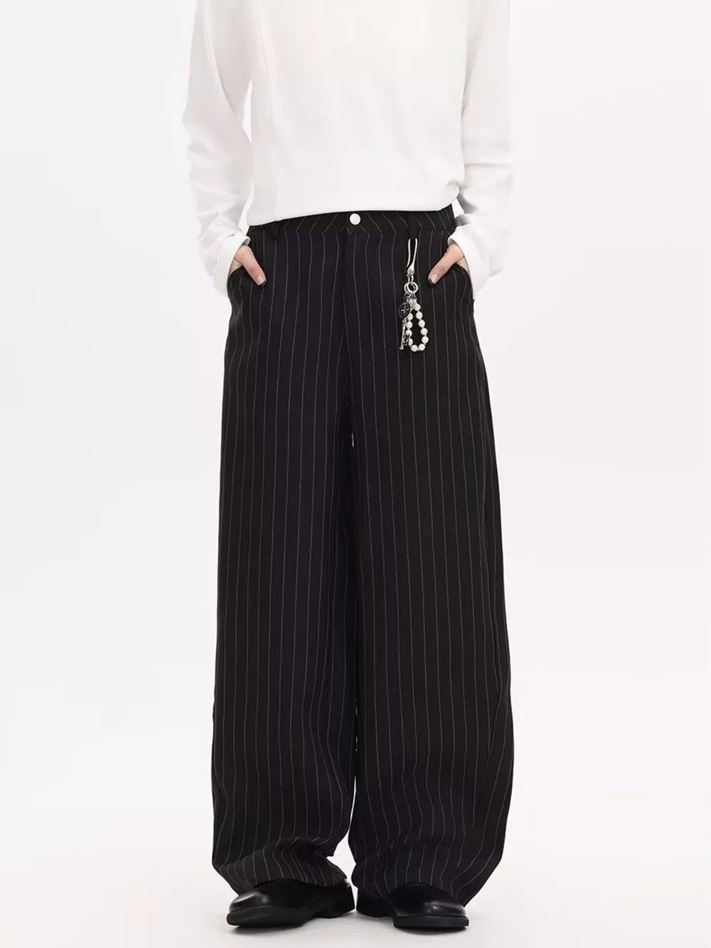 Black pinstripe wide-leg sweatpants with a pearl charm detail.