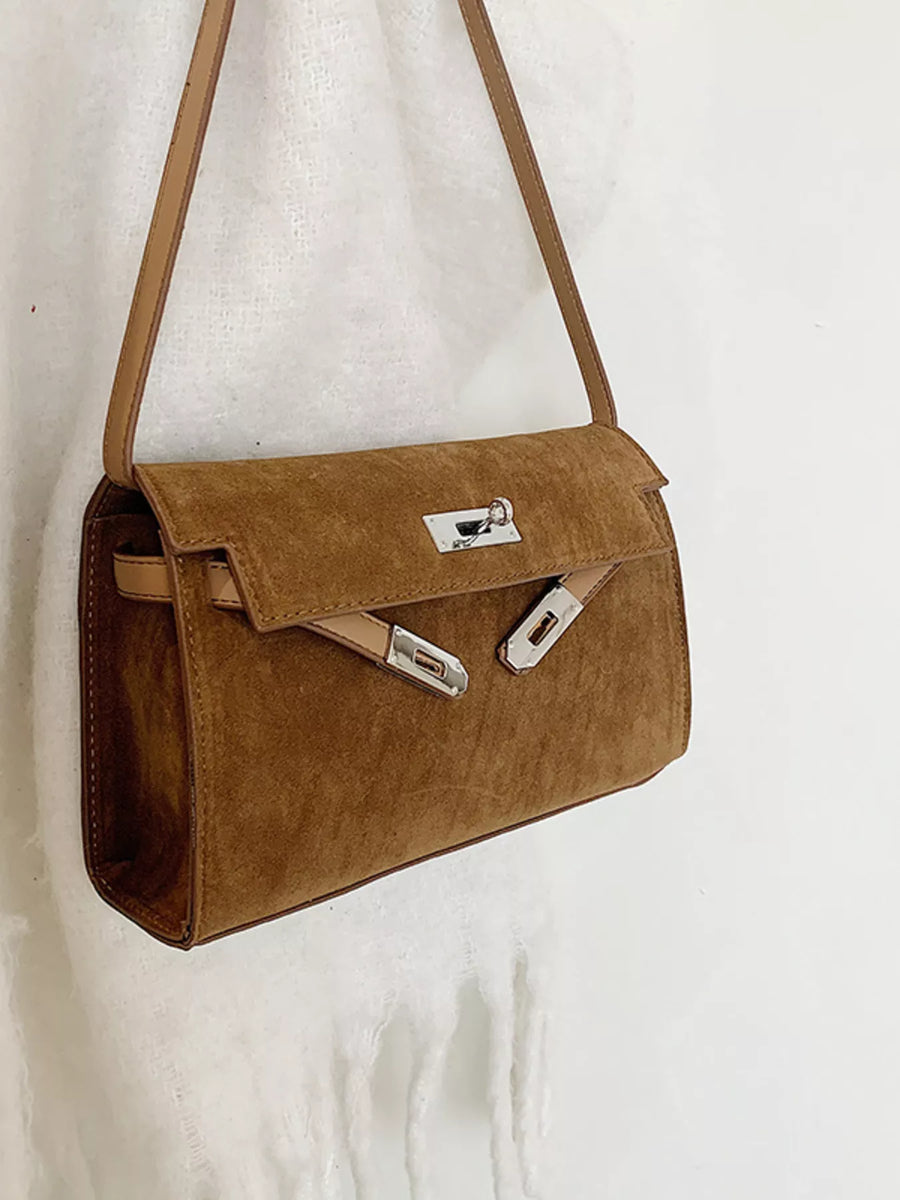 Brown suede shoulder bag with silver hardware and a chic buckle detail.