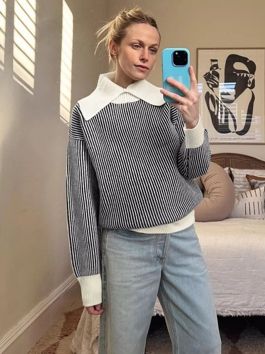 Black striped knit sweater with white contrast collar and cuffs.