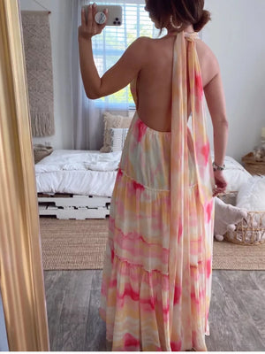 Vibrant tie-dye maxi dress with halter neckline and open back, tiered skirt.