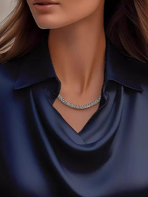 Dark blue satin cowl neck blouse with a silver necklace.