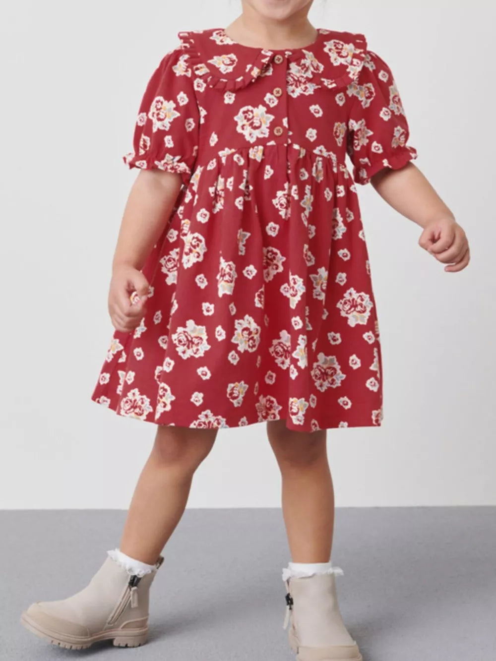 Red cotton baby dress with floral print, ruffle collar, button front, and puff sleeves.